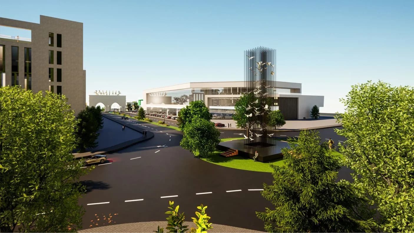 Tree-lined road leading to a modern commercial hub with a glass tower