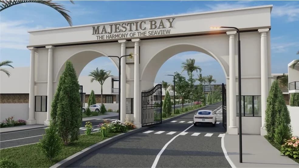 Majestic Bay estate entrance, an arched white gateway on a palm-lined road