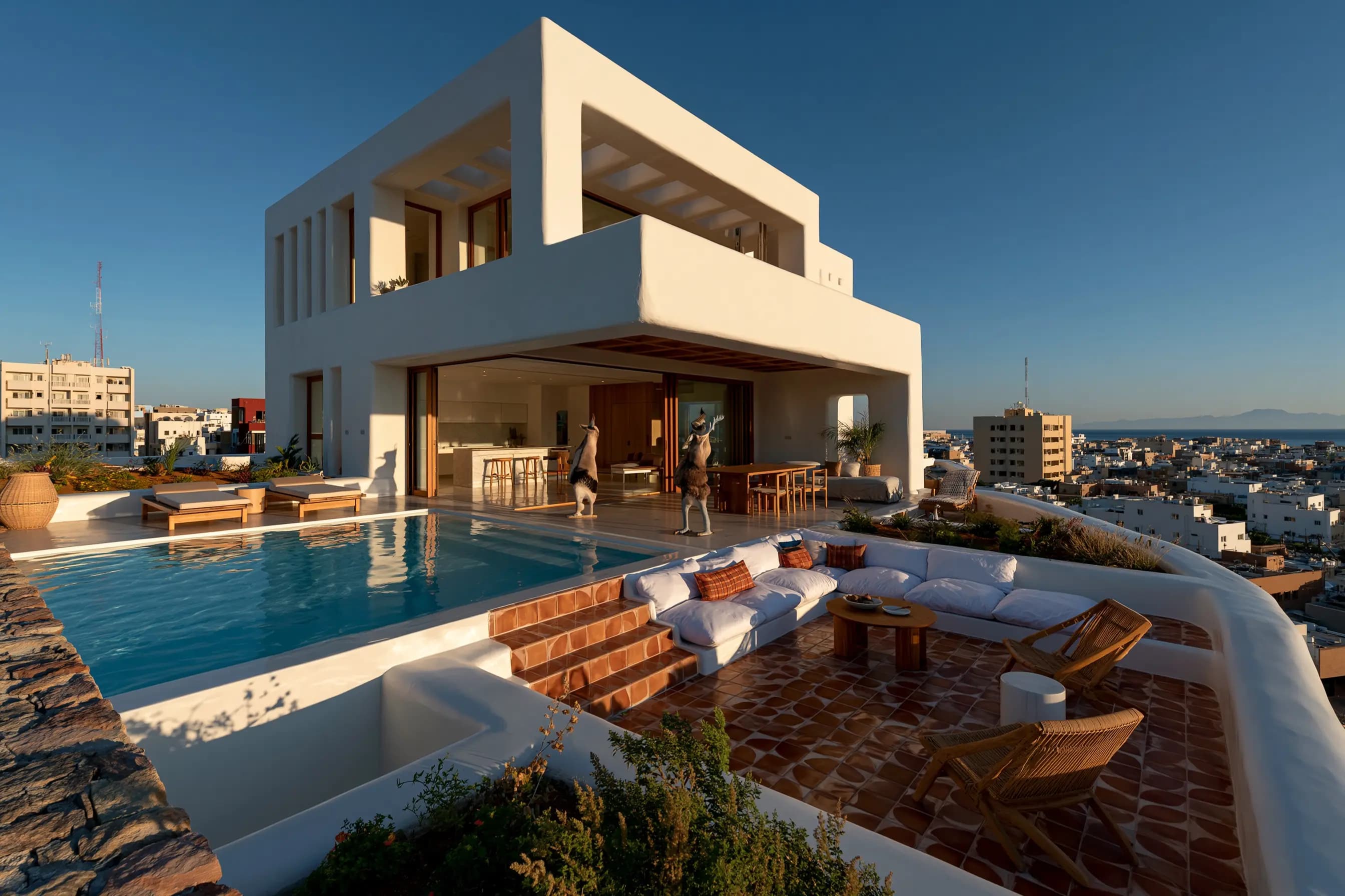 Whitewashed modern home with a rooftop pool overlooking the coastal skyline